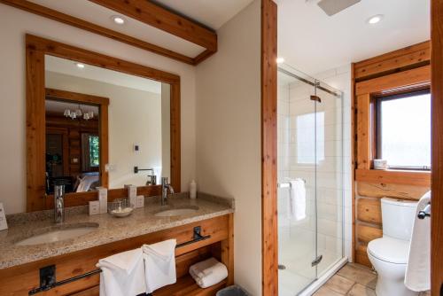 a bathroom with two sinks and a shower at Mike Wiegele Helicopter Skiing in Blue River