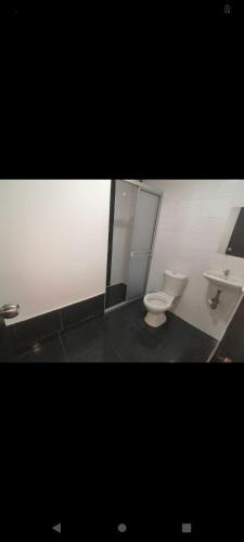 a bathroom with a toilet and a sink at Hospedaje Luna Dorada in Manizales