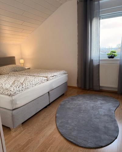 a bedroom with a bed and a large window at Ferienhaus Eiforia in Gerolstein