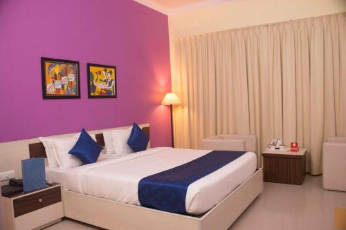 a bedroom with a large bed with purple walls at The Kannelite in Jamshedpur