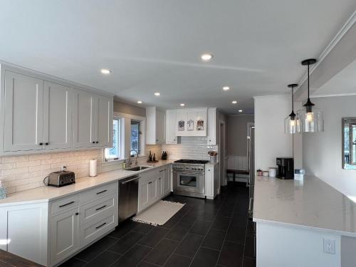 a kitchen with white cabinets and a black tile floor at Mill Lane in Stowe