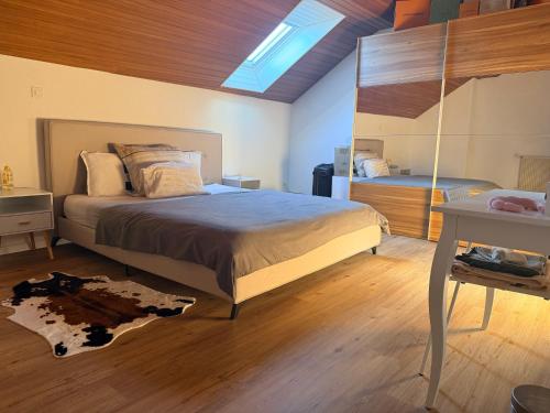 ein Schlafzimmer mit einem großen Bett und einem Spiegel in der Unterkunft Oumaya in Erlach