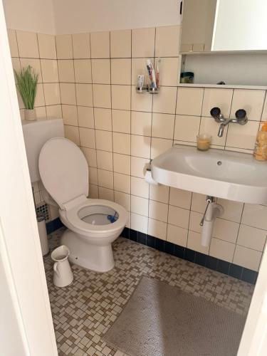 ein Badezimmer mit Toilette und Waschbecken in der Unterkunft Oumaya in Erlach
