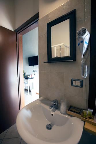 a bathroom sink with a mirror and a hair dryer at Locanda del Borgo in Langa in Prunetto