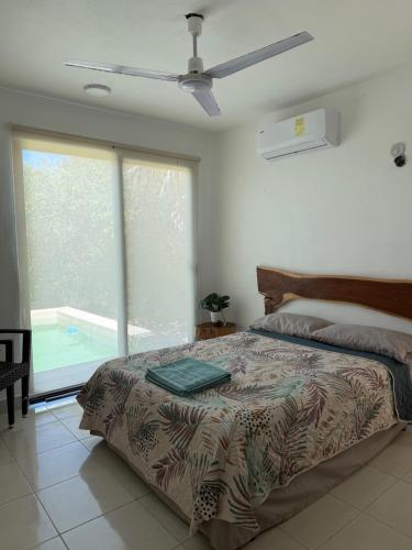 a bedroom with a bed and a ceiling fan at Casa Nora in Sisal