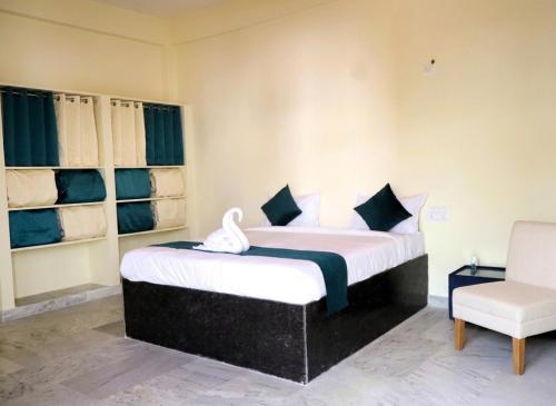 a bedroom with a bed and a chair in it at MMG Resorts in Nāspur