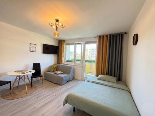 a bedroom with a bed and a couch and a table at Ostoja Apartament Bytom Miechowice 24H - blisko A1, Gliwice 15 min in Bytom