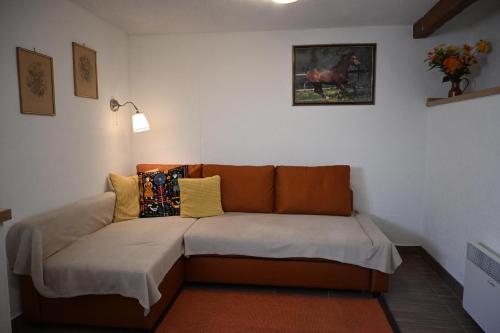 Eine Couch im Wohnzimmer mit einem Bild eines Pferdes an der Wand in der Unterkunft FILUTE in Vrbovsko