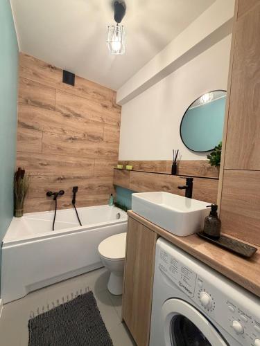 a bathroom with a sink and a washing machine at Ostoja Apartament Bytom Miechowice 24H - blisko A1, Gliwice 15 min in Bytom