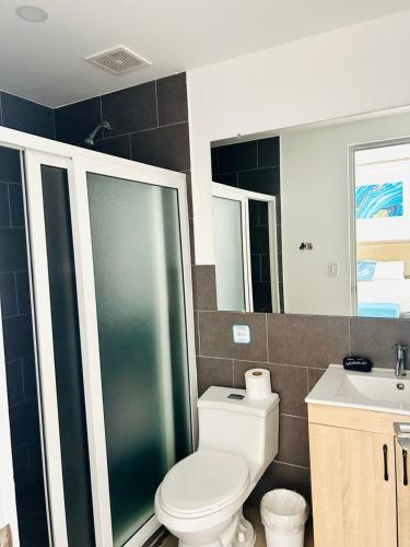 a bathroom with a toilet and a shower and a sink at The Views Resort in El Zonte