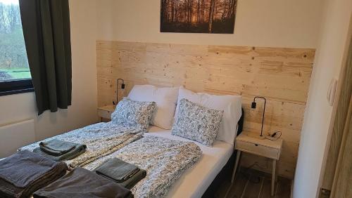 a bedroom with a bed with a wooden headboard at Ohuta-Barn Vendégház in Parád