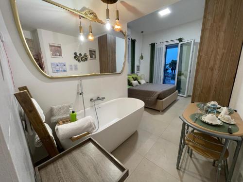 a bathroom with a tub and a table and a mirror at B&B Villa Alma in San Costanzo