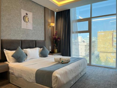 a bedroom with a large bed with a large window at فندق ليان بارك Lian Park Hotel in Al Khobar