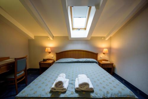 a bedroom with a bed with two towels on it at Hotel Kastoria in Kastoria City in Kastoria