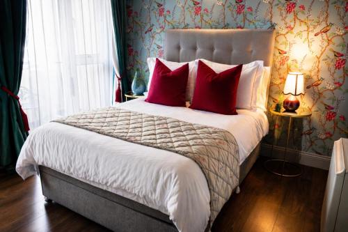 a bedroom with a large bed with red pillows at Dog-friendly Seaview Apartment in Dungarvan