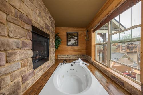 a bath tub in a room with a stone wall at Hilltop Haven in Gatlinburg