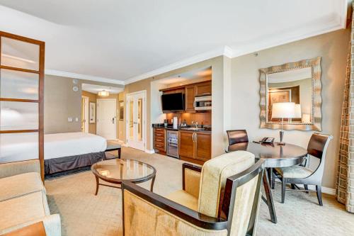a hotel room with a bed and a dining room at The Signature MGM Las Vegas in Las Vegas