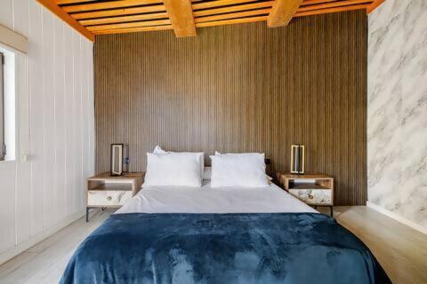 a bedroom with a large bed with two night stands at Mar no Camiño. Terraza, bañera con vista al mar. in Brens