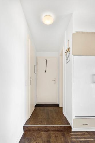 a hallway with white walls and a white door at Studio with panoramic view in Bellerive