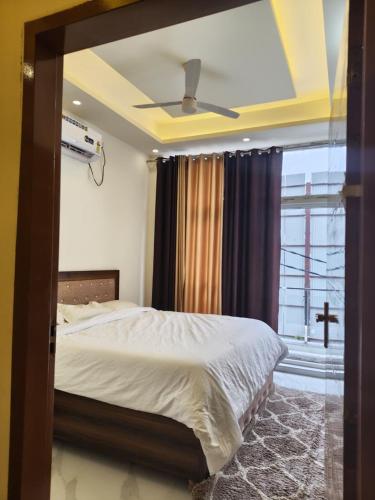 a bedroom with a large bed with a window at The Hills & Waves in Rishīkesh