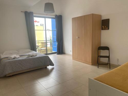 a bedroom with a bed and a sliding glass door at Porta 28 in Quinta do Anjo