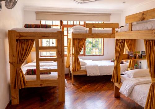 a room with three bunk beds and a window at Paisa Hostel Medellín in Medellín