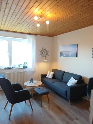 a living room with a blue couch and a table at Sielpferdchen Bensersiel in Bensersiel