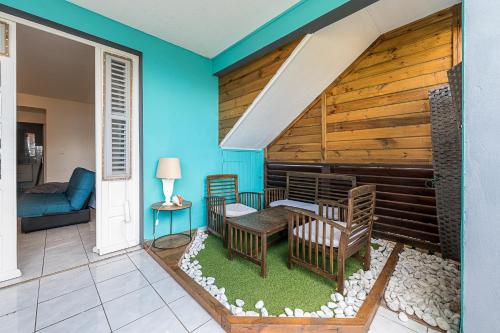 a house with a porch with a table and chairs at 2-3 personnes - Vue Mer et Piscine - Anse à l Âne - trois Îlets - Plage 2 min en voiture in Les Trois-Îlets
