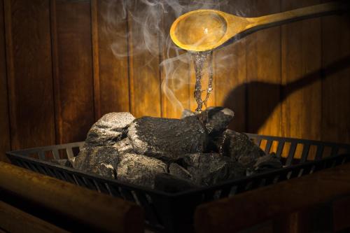 a wooden spoon pouring water onto a pile of coal at Rheinhotel Rüdesheim - Wellness in Rüdesheim am Rhein
