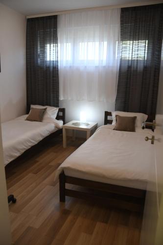 a room with two beds and a table in it at Prestige in Šabac