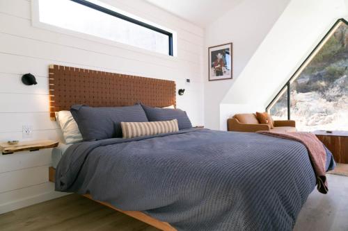 a bedroom with a bed with a large window at A-Frame Cliffside Studio Cabins in South Fork