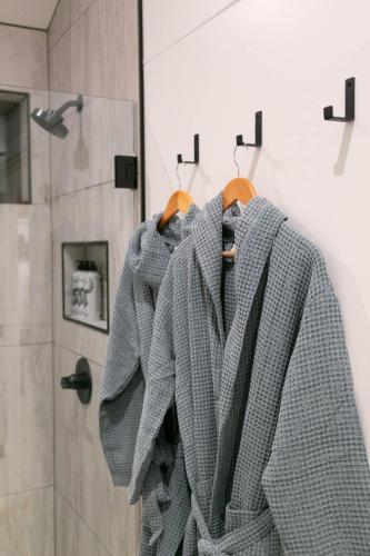 a gray sweater is hanging on a rack in a bathroom at A-Frame Cliffside Studio Cabins in South Fork