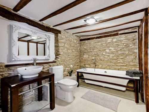 a bathroom with a tub and a toilet and a sink at 3 Bed in Witney oc-82478 in Hailey