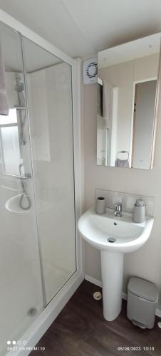 a white bathroom with a sink and a shower at Dulce Casa 34 2 bedroom with hot tub in Grantown on Spey