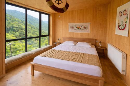 a bedroom with a bed and a large window at Chateau Chao in Khulo