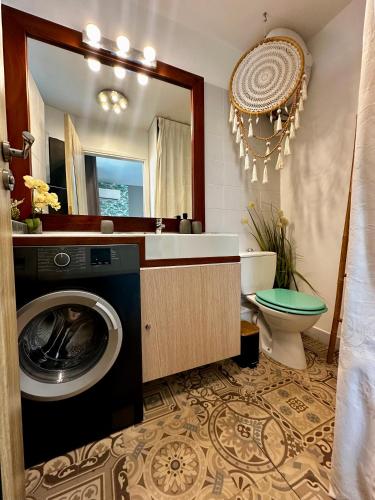 a bathroom with a washing machine and a mirror at PARADISIAC LAGOON in Saint-François