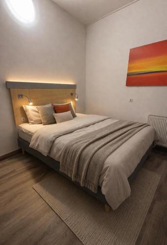 a bedroom with a large bed with a painting on the wall at Hotel Moji 5 Solingen in Solingen