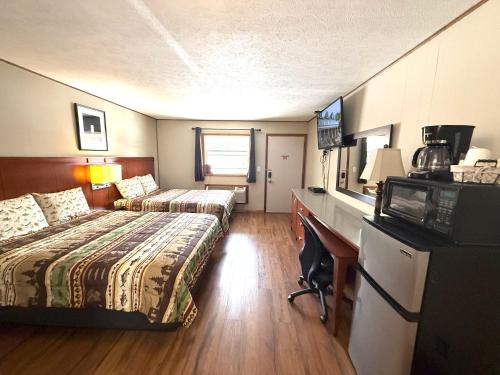 a hotel room with two beds and a desk at Hunter's Friend Resort near Table Rock Lake in Branson
