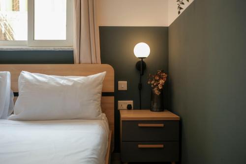 a bedroom with a bed and a table with a lamp at Tan-Nanna by Shmoo, Sliema Ferries in Sliema