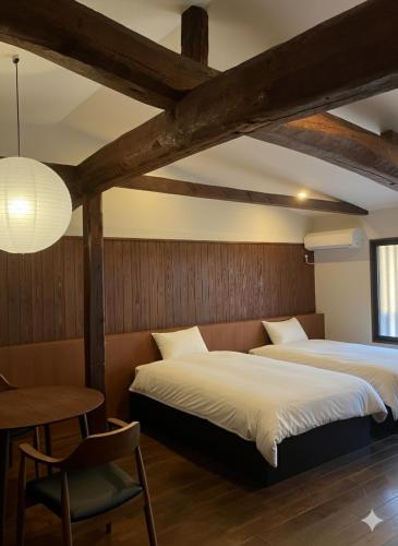 two beds in a room with a table and a chair at BLANKS - Vacation STAY 37519v in Taisha