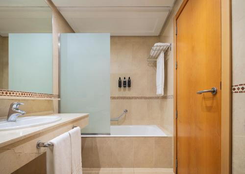 a bathroom with a tub and a sink at Dorma Juan de Austria in Valladolid
