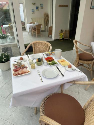 a white table with plates of food on it at Pension Störtebeker in Prerow