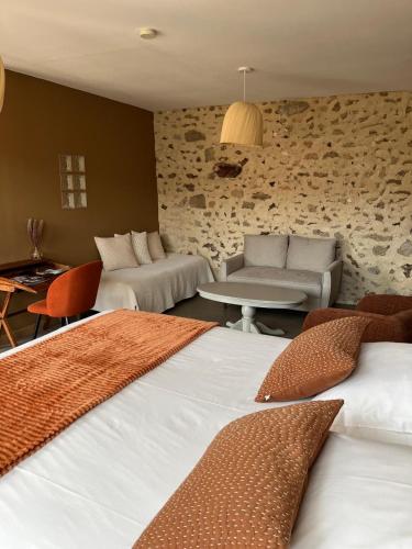 a hotel room with two beds and a living room at La Fermette Champenoise in Jonquery