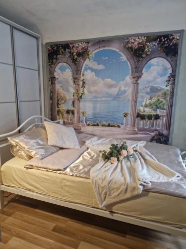 a bedroom with a bed with a painting of an ocean at Ivory & Rose Studio in Tartu