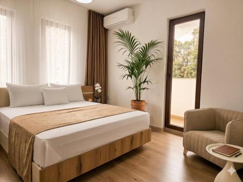 a bedroom with a bed and a chair and a plant at Kasibel Suites in Sandanski