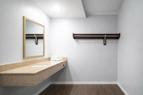 a bathroom with a sink and a mirror at Quarters Inn & Suites in Antioch
