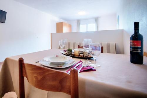 a table with a bottle of wine and glasses on it at Apartments Bruna in Lastovo