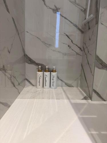 two bottles ofodorizers sitting on a shelf in a bathroom at Appartamento Laghetto in Segrate