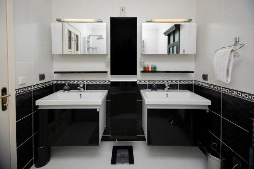 a black and white bathroom with two sinks and mirrors at Villa Cecilia in Göcek