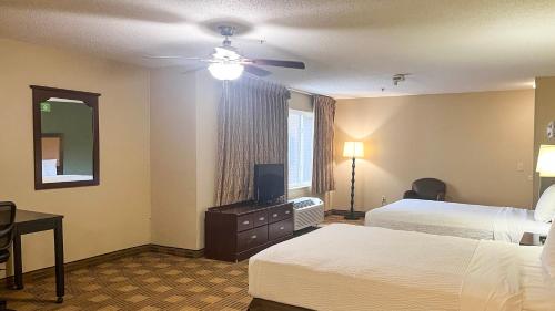 a hotel room with two beds and a television at Studio 6 Chantilly VA Washington Dulles Airport in Chantilly